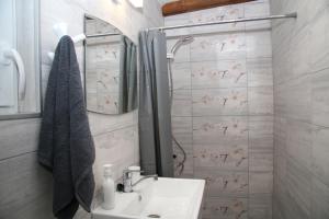 a white bathroom with a sink and a shower at Charming studio in the city center in Plovdiv