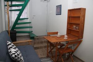 a living room with a table and a green staircase at Charming studio in the city center in Plovdiv