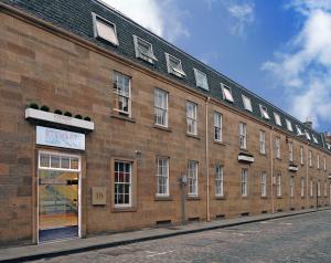 a large brick building with windows on a street at Stewart by Heeton Concept - Aparthotel Edinburgh in Edinburgh