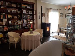 - un salon avec une table, des chaises et une étagère dans l'établissement Casa encantadora con piscina privada y chimenea, à Las Jaras