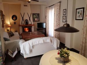 ein Wohnzimmer mit einem Sofa und einem Kamin in der Unterkunft Casa encantadora con piscina privada y chimenea in Las Jaras