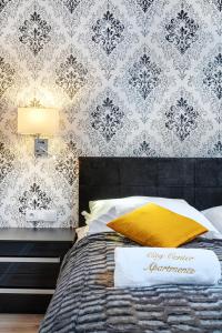 a bedroom with a bed with a black and white wallpaper at Apartamenty City Center Cicha 8 in Krynica Zdrój