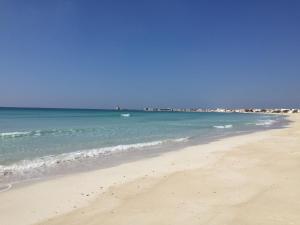 a sandy beach with the ocean in the background at Affittacamere Torre Lapillo in Torre Lapillo