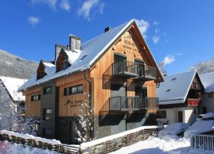 ein großes Holzhaus mit Schnee auf dem Boden in der Unterkunft Apartments and Rooms Bernik in Kranjska Gora