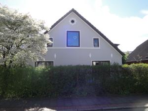 Una casa blanca con una ventana azul. en Urlaub in der edition Schwarzarbeit en Bremerhaven