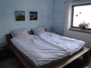 Cette chambre comprend un grand lit et une fenêtre. dans l'établissement Urlaub in der edition Schwarzarbeit, à Bremerhaven
