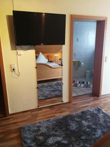 - une chambre avec un lit et une télévision à écran plat dans l'établissement Gästehaus Moni Jäger, à Weyher