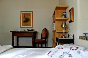 a bedroom with a bed and a desk and a chair at I Fiori di Miranda in Casarza Ligure