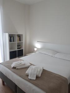 uma cama branca com duas toalhas em cima em Affittacamere Risorgimento em Lecco