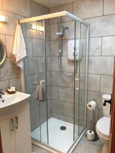 um chuveiro com uma porta de vidro na casa de banho em Beachcomber Cottages em Ballyconneely