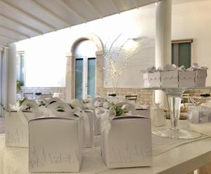 Cette chambre dispose de chaises blanches et d'une table avec des gâteaux. dans l'établissement FEMily B&B Bed and Breakfast di Puglia in - Bari, à Grumo Appula