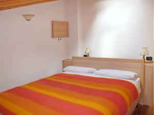 a bedroom with a colorful striped bed with two pillows at Baitina Viola in Valdidentro