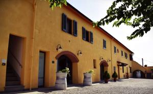 a yellow building with flowerpots in front of it at Agriturismo Luggiano in Vinci