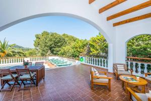 een patio met een tafel en stoelen en een zwembad bij Villa Benmar in Son Parc