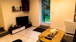 ein Wohnzimmer mit einem Tisch und einem TV in der Unterkunft Ferienwohnung Sorgatz in Königstein an der Elbe