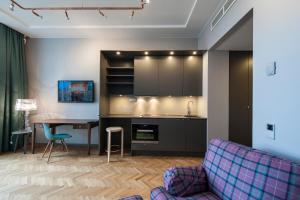 een keuken en een woonkamer met een tafel en een bank bij Apartments By Ligula, Hammarby Sjöstad in Stockholm