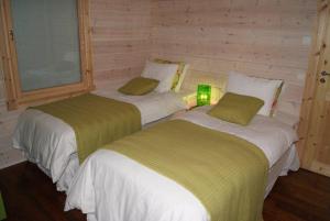Habitación de madera con 2 camas y lámpara en Villa Ainotar, en Äkäslompolo