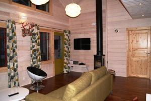 Una sala de estar con un sofá y una chimenea. en Villa Ainotar, en Äkäslompolo