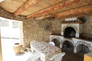 a dining room with a table and a fireplace at ARENDA Villa Fortuna Miami Playa in Miami Platja