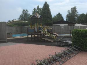 a playground with a slide in a backyard at Het Groene Hart in Putten
