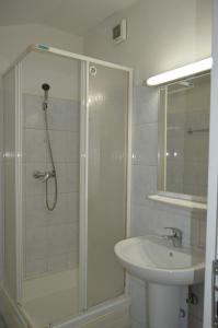 ein Bad mit einer Dusche und einem Waschbecken in der Unterkunft Kollege Hostel in Cluj-Napoca