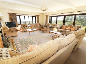 ein großes Wohnzimmer mit Sofas und Tischen in der Unterkunft Ghyll Bank House in Staveley