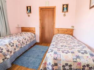 a bedroom with two beds and a door at Ocean Heights in Coomhola Bridge