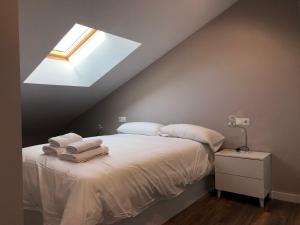 a bedroom with a bed with white sheets and a skylight at PROBER - CHAMOIX in Pas de la Casa