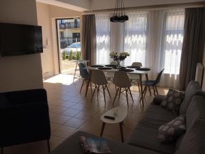 a living room with a couch and a table and chairs at Balticsand Apartament in Mielno