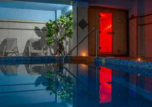 a house with a swimming pool with a red door at Gea Kaimaktsalan Hotel & Spa in Kato Loutraki