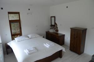 a bedroom with a bed and a dresser and a mirror at Borislav's Farmhouse in Ogled