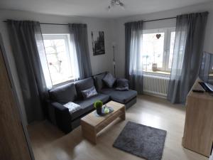 sala de estar con sofá y mesa de centro en Apartmenthaus Geniusbank OL, en Wilhelmshaven