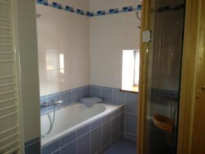 baño con bañera y ventana en gite la Fraiseraie, en Flassigny