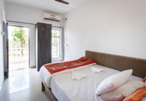a bedroom with a bed with white sheets and a window at De Lavender Luxury sea view Guest Houses in Agonda