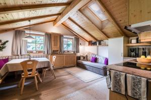 a kitchen and living room with a table and a couch at Arbea Apartments in Ortisei