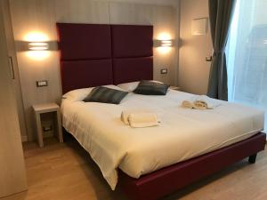 una camera da letto con un grande letto con due asciugamani di Verona Apartments & Rooms a Verona