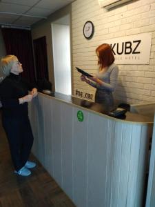 クラスノゴルスクにあるTHE KUBZ Capsule Hotelの二人の女性が事務所の窓口に立っている