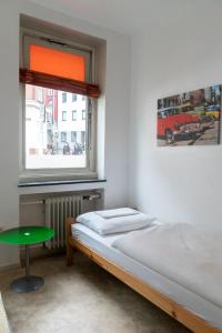 a bedroom with a bed and a window at Hostel Aachen in Aachen