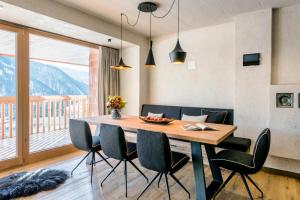 een eetkamer met een houten tafel en stoelen bij Die Alm 1350 in Saalbach Hinterglemm