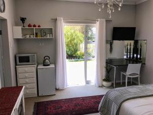 a bedroom with a bed and a desk with a microwave at Gate 66 in Somerset East