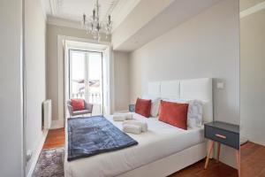 biała sypialnia z dużym białym łóżkiem z czerwonymi poduszkami w obiekcie Casa Portuguesa Combro w Lizbonie