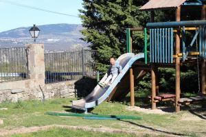a boy on a slide at a playground at Hotel Sierra Oriente in Guadarrama
