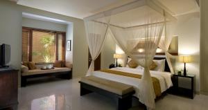 a bedroom with a large bed with a canopy at The Kunja Villa-Hotel in Seminyak +30 photos