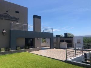 vistas a un edificio con patio de césped en Stefano lll en Villa Carlos Paz