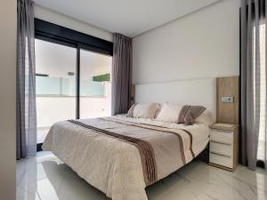 a bedroom with a large bed and a large window at Olivar de Roda Golf - Villa - 1409 in Roda +23 photos