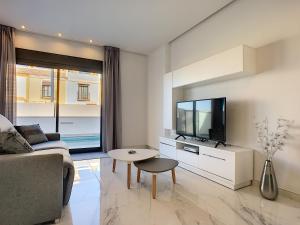 a living room with a couch and a tv at Olivar de Roda Golf - Villa - 1409 in Roda
