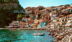 a boat in a body of water with houses at Sunny Garden in Plataria