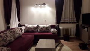uma sala de estar com um sofá e uma mesa em Jahorina H4 em Jahorina