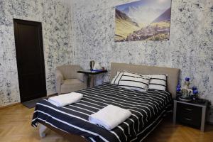 ein Schlafzimmer mit einem Bett mit einer schwarz-weißen gestreiften Decke in der Unterkunft Mia B&B Tbilisi in Tbilisi City