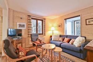 ein Wohnzimmer mit einem blauen Sofa und einem Tisch in der Unterkunft Beautiful apartment in the Mayens de Sion, 500m from the Ours piste - 4 Vallées in Agettes